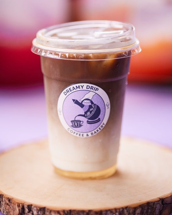 A layered Dreamy Drip iced coffee served on a slice of wood
